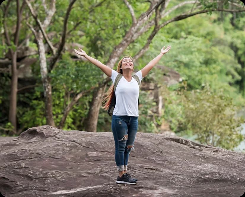 A woman enjoying time outdoors in a green woodland
